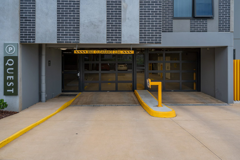 Perforated commercial garage doors across a car park entrance