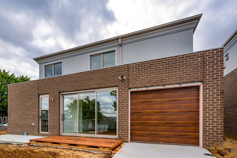 Timber-look garage door on a brick home